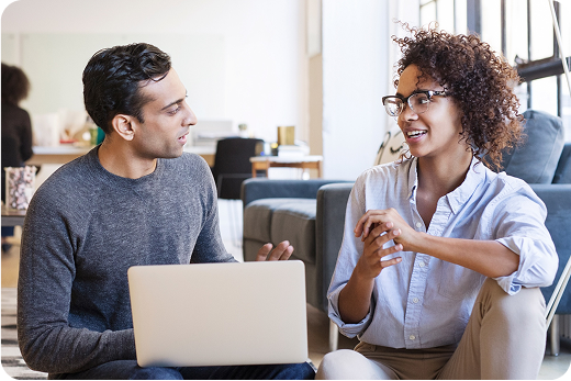 Two coworkers having an animated discussion in a modern office space.